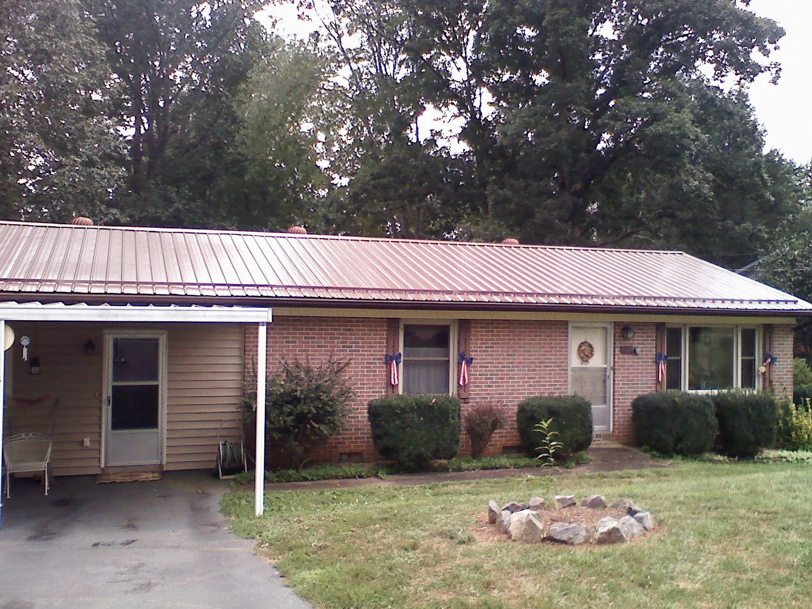 Bronze metal roof and carport on a brick ranch home — Roof Repair work by our crew in Kandiyohi